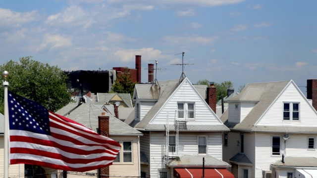Suburban wooden row houses and American flag in Brooklyn, New York City