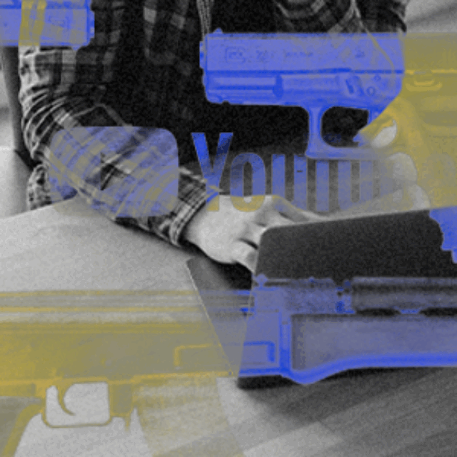 A person in a black-and-white plaid shirt sits at a desk typing on a computer. The photo is overlaid with graphic-style blue-and-yellow firearms and the YouTube logo.
